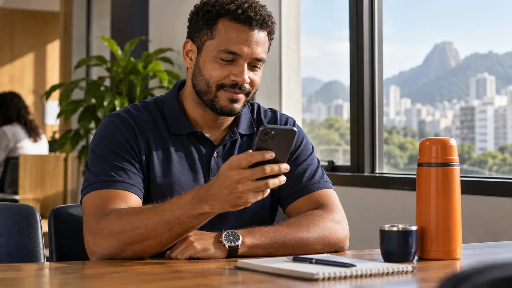 Trabalhador consultando o celular, com relógio de pulso visível durante uma pausa.