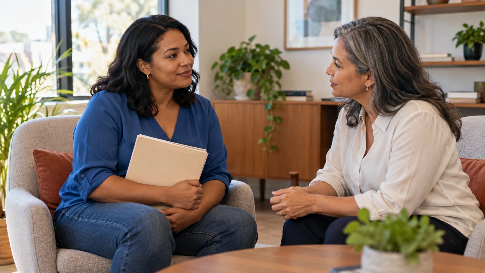 Duas mulheres conversam em uma sala reservada sobre o benefício do INSS para mulher afastada por violência doméstica.
